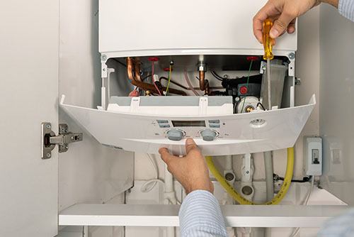 Heating technician repairing a residential boiler in Granite Bay