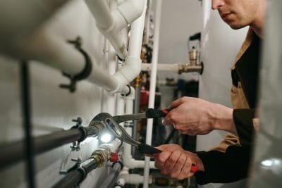 Technician inspecting commercial plumbing pipes in Granite Bay
