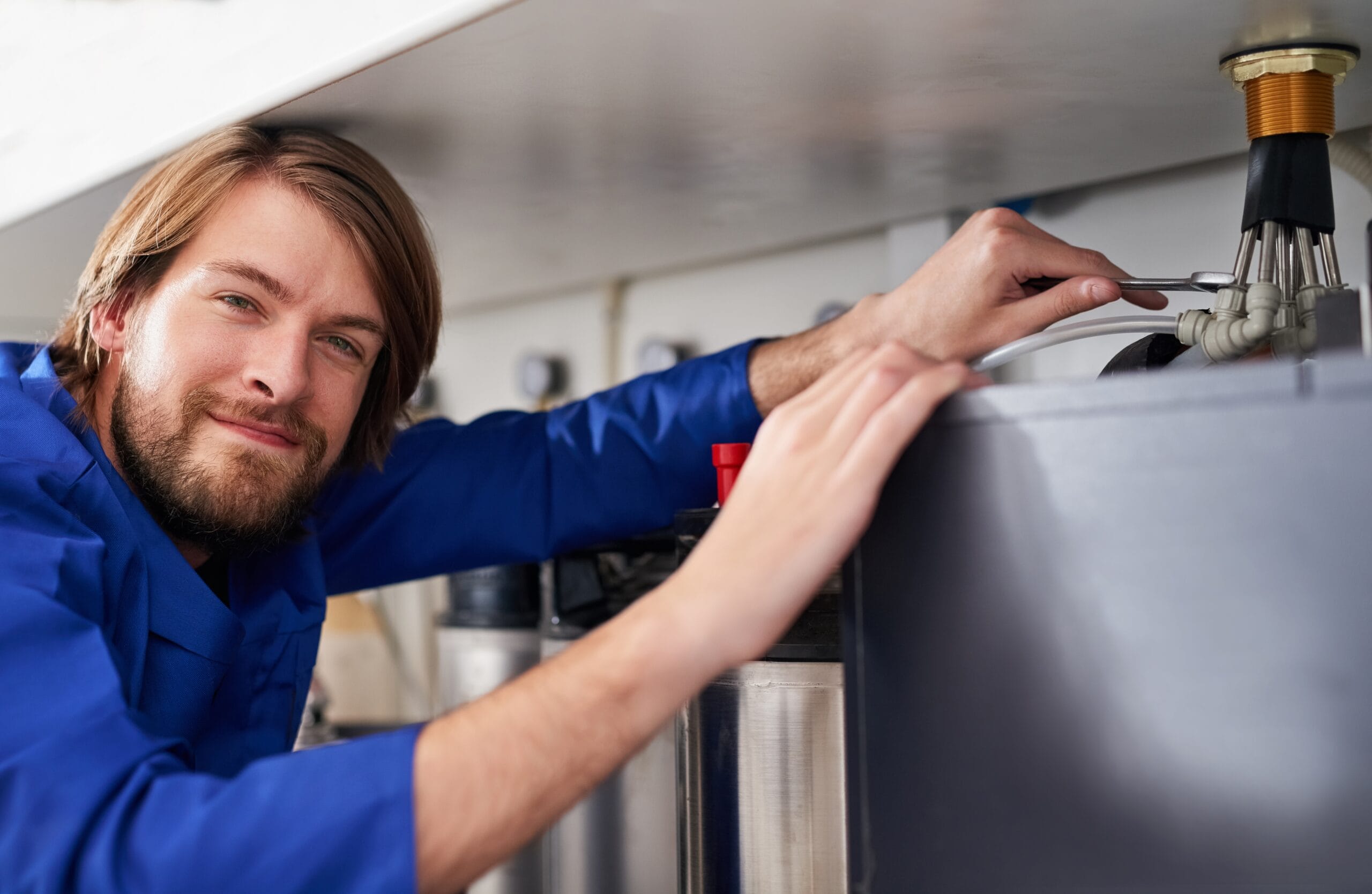 Technician servicing a residential water heater tank in Granite Bay